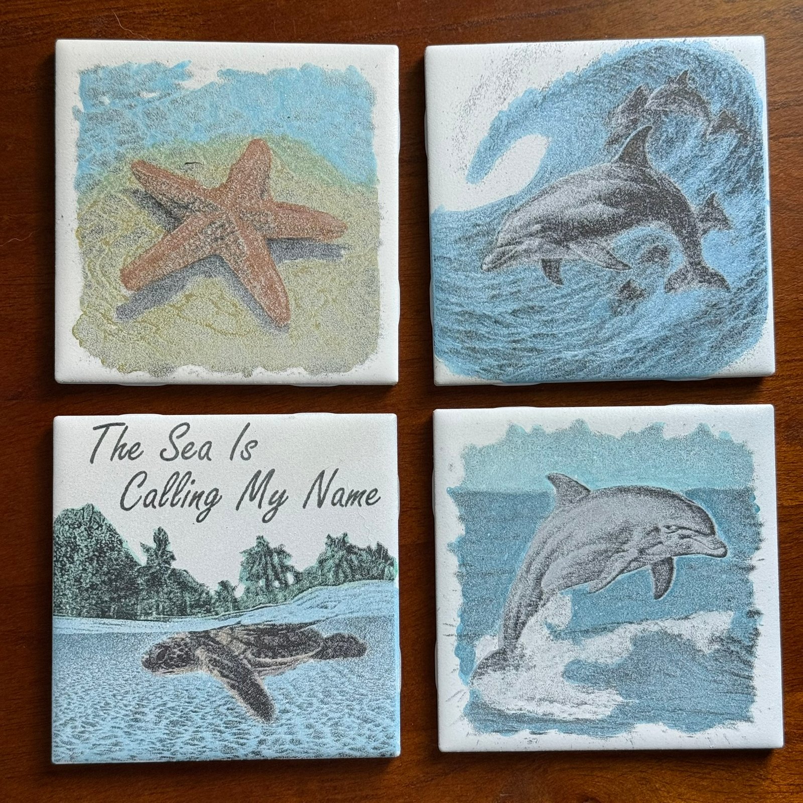 Beach-themed ceramic coasters with coastal colors styled on a wood table